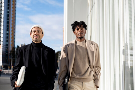 Colleagues walking in business attire by modern architecture in Barcelona