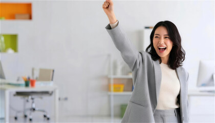 オフィスで歓喜のガッツポーズをする女性社員