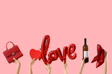 Female hands with bag, word LOVE, wine and high heels on pink background. Valentine's Day...