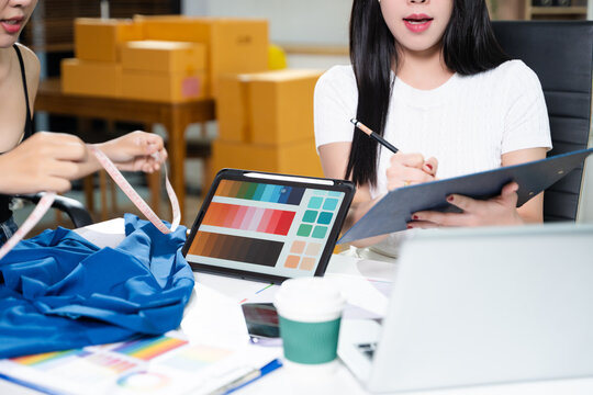 Creative fashion designers collaborating with fabric and color palette using digital tablet. Modern fashion studio, textile planning and startup business concept - Powered by Adobe