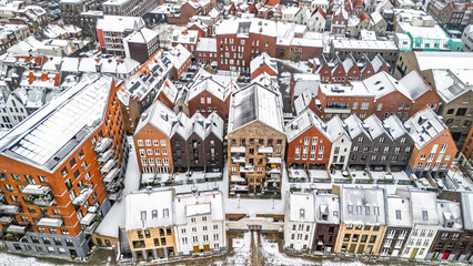 Aerial drone view of houses roofs covered with snow, residential area neighborhood and town streets in snowy winter weather, Venlo city, the Netherlands