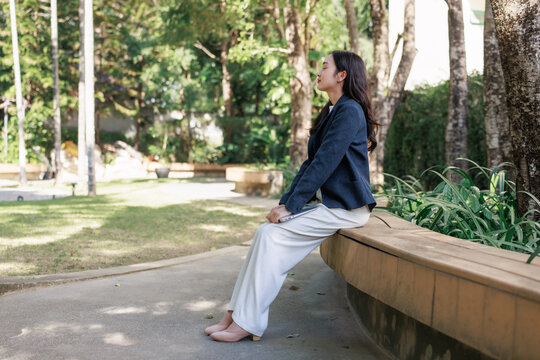 Young woman relaxing meditating with laptop outdoors
