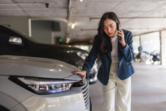 Woman calling emergency for car damage in parking