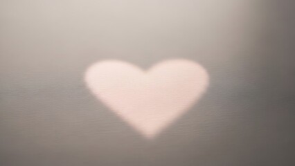 Fototapeta premium Softly glowing heart shape perfect for a gentle valentine's day message, symbolizing tender love and quiet affection in a blurred, romantic setting