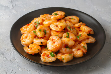 Delicious Seafood Grilled Shrimp - Shrimp in a garlic butter sauce with lemon and parsley sprinkled in a frying pan