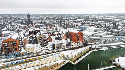 Snowy Venlo town waterfront near Maas river aerial drone view, winter cityscape with rooftops covered with snow, winter weather in Limburg, the Netherlands