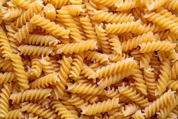 Pile of raw fusilli pasta close-up. Italian pasta, pasta cones texture, top view