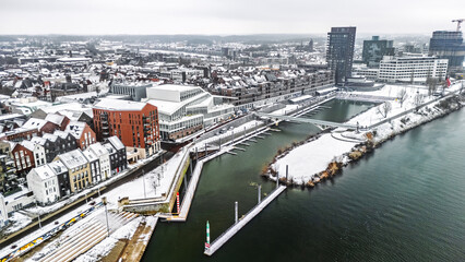 Snowy Venlo town waterfront near Maas river aerial drone view, winter cityscape with rooftops covered with snow, winter weather in Limburg, the Netherlands