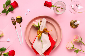 Beautiful table setting for Valentine's Day with rose flowers, candle and envelope on pink...