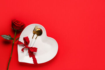 Beautiful table setting for Valentine's Day with rose flower on red background