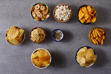 Fototapeta premium Assorted snacks in pottery bowls on grey background