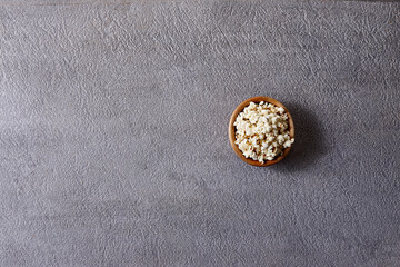 Assorted snacks in pottery bowls on grey background