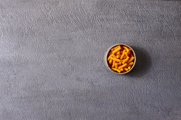Assorted snacks in pottery bowls on grey background