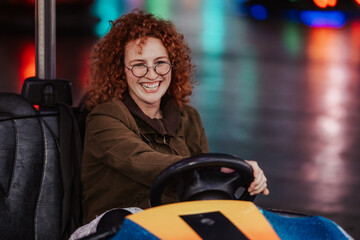 Young woman having fun driving bumper car
