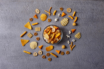 Assorted snacks in pottery bowls on grey background
