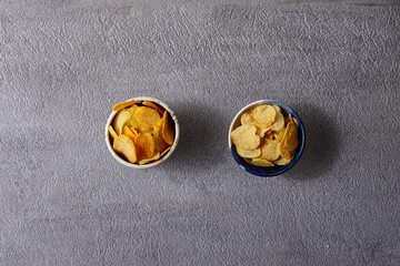Assorted snacks in pottery bowls on grey background