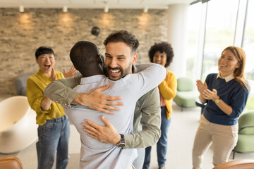 Colleagues celebrating success with a warm hug in a casual office setting