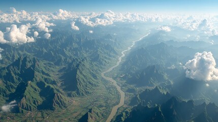 Aerial view of a vast, mountainous terrain, with a river winding through lush green valleys
