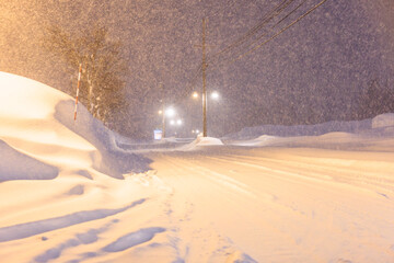 夜の街灯に照らされる静かな雪道