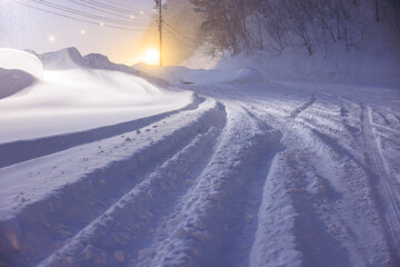 夜の街灯に照らされる静かな雪道
