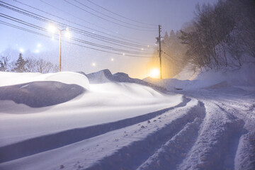 夜の街灯に照らされる静かな雪道
