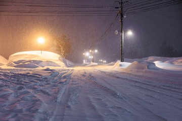 夜の街灯に照らされる静かな雪道