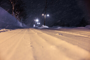 夜の街灯に照らされる静かな雪道