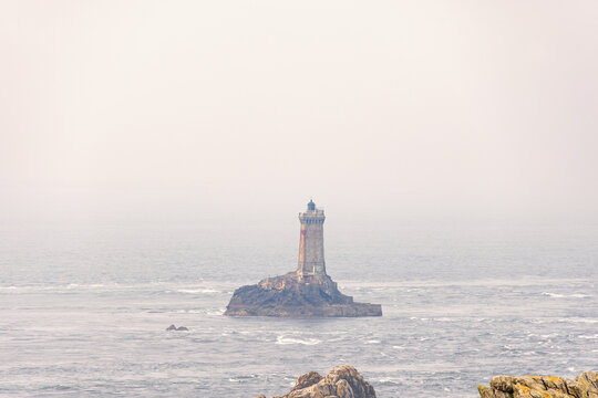 Lighthouse in mist on a rock at the Pointe du raz in Bretagne