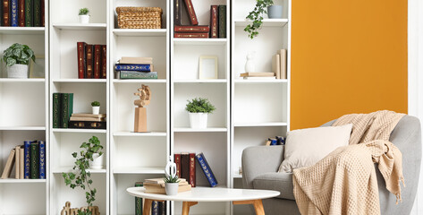 Interior of stylish home library with armchair, table and bookshelves © Pixel-Shot
