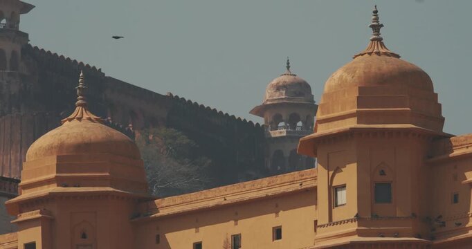 Jaipur, Rajasthan, India. Amber Fort. Slow Motion Pigeons Fly Above Towers Of Amer Fort Or Amber Fort, Amer. Amer Palace Is Great Example Of Rajput Architecture. Principal Tourist Attraction In Jaipur