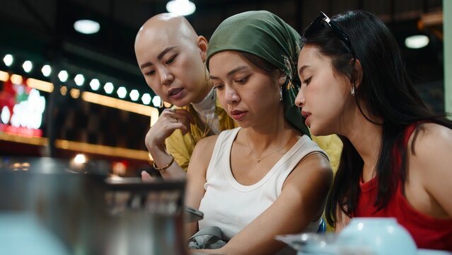 Thai friends enjoying moo krata together, connecting and sharing a meal