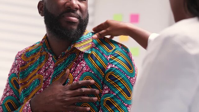 African Male Patient With Chest and Shoulder Pain Consulting Female Doctor in Hospital - Powered by Adobe