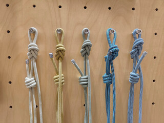 Display of Knotted Metallic Cord Samples on Wood