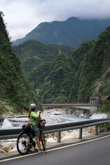 Woman bikepacking through Taroko Gorge with Liwu River in Taroko National Park, Taiwan