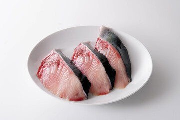 白い皿に並んだブリの切り身　白背景