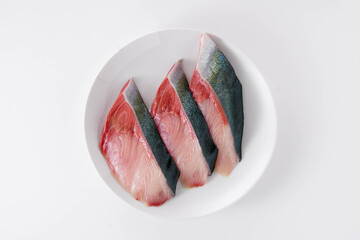 白い皿に並んだブリの切り身　白背景