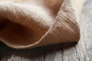 Jute fabric on wooden background.