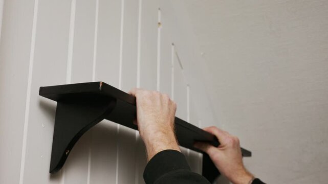Holding shelf against wall to check placement