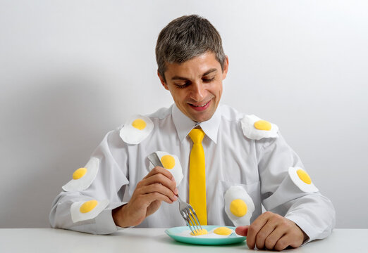 Office worker in surreal fried egg attire eating breakfast with a smile