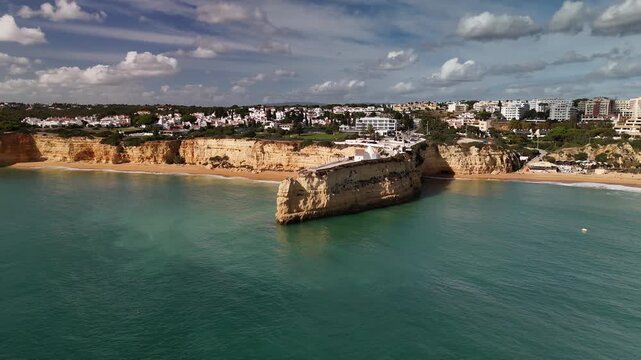 Circling Aerial Drone View of the Iconic Nossa Senhora da Rocha White Church Located on a Dramatic Limestone Promontory in Algarve Portugal