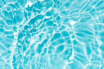 Blue water with ripples on the surface. Defocus blurred transparent blue colored clear calm water surface texture with splashes and bubbles. Water waves with shining pattern texture background.