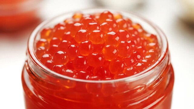 Close-up view of a jar filled with shiny red salmon roe ready to eat for a delicious meal