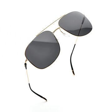 Flying sunglasses with black lenses and gold frame isolated on white background, perfect for summer fashion promotion