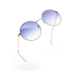 Flying round sunglasses with blue gradient lenses, isolated on white background for summer fashion accessories