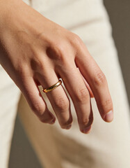 Close-Up of Elegant Human Hand Wearing Simple Gold Ring in Soft Natural Light, Neutral Blurred Background, Luxury Minimal Aesthetic for Jewelry Branding, Lifestyle, and Premium Visual Design
