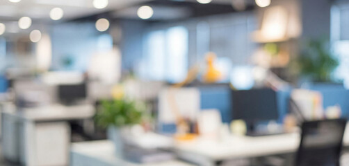 Fototapeta premium Modern workspace with blurred desks and plants, showcasing a contemporary office environment filled with natural light.