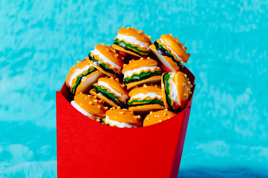 Close view of mini burgers with lettuce and cheese in red packaging