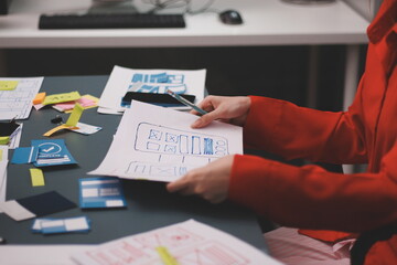 Team of uxui designers pointing at computer screen, discussing new mobile app design in the office