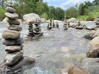 Balanced stone stacks in shallow river stream, zen meditation and harmony nature concept