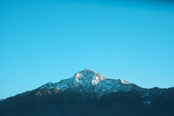 Obraz premium Snow-capped peak in the Italian Alps under clear blue sky, majestic alpine mountain landscape with copy space
